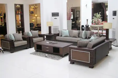 modern wooden sofa set design in Pakistan with fabric cushions and wooden center table in living room